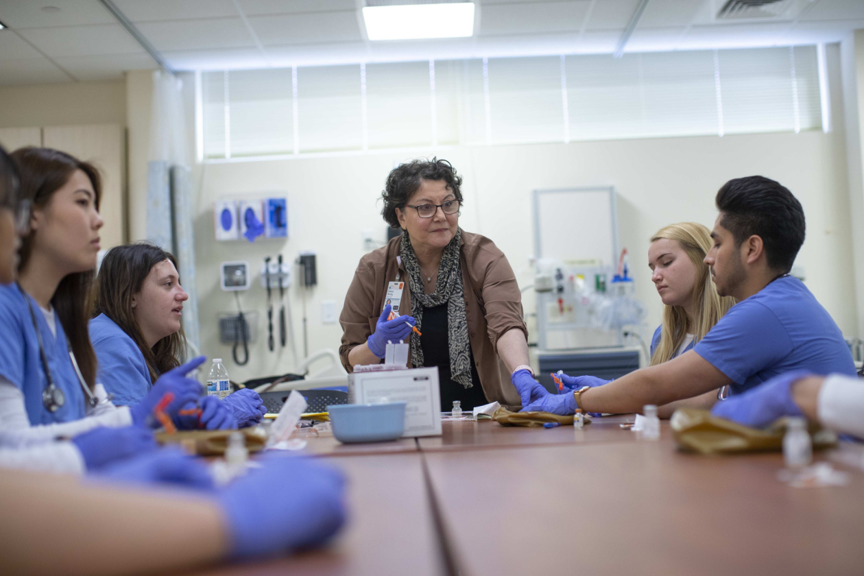 nursing professor demonstrates to students during class